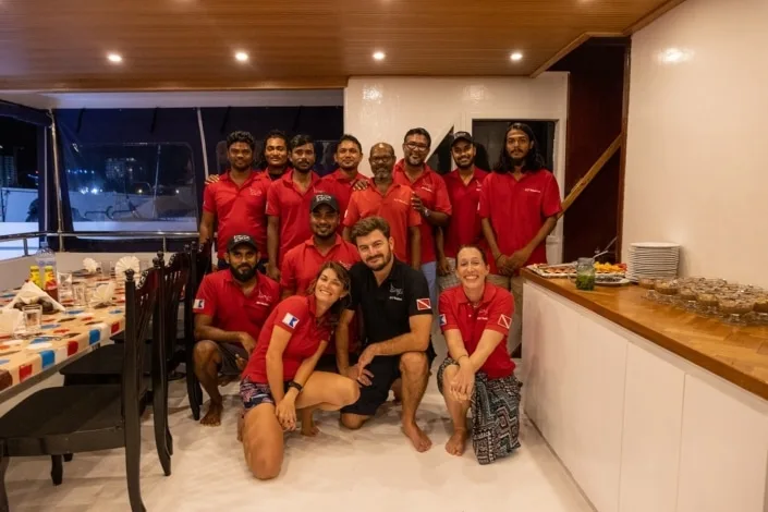 Equipe souriante posant sur le pont d'un bateau de croisière