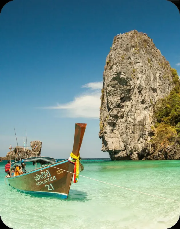 Longtail boat avec passagers navigue dans une eau turquoise claire