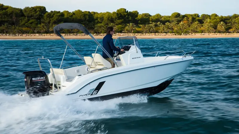 Homme conduisant un bateau blanc rapide sur une mer bleue