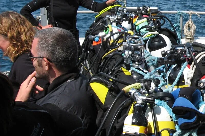 Plongeurs sur un bateau avec leur équipement de plongée complet