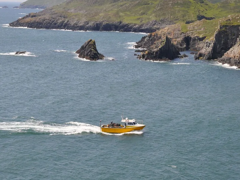 Bateau de plongée jaune navigue sur une mer bleue près des côtes