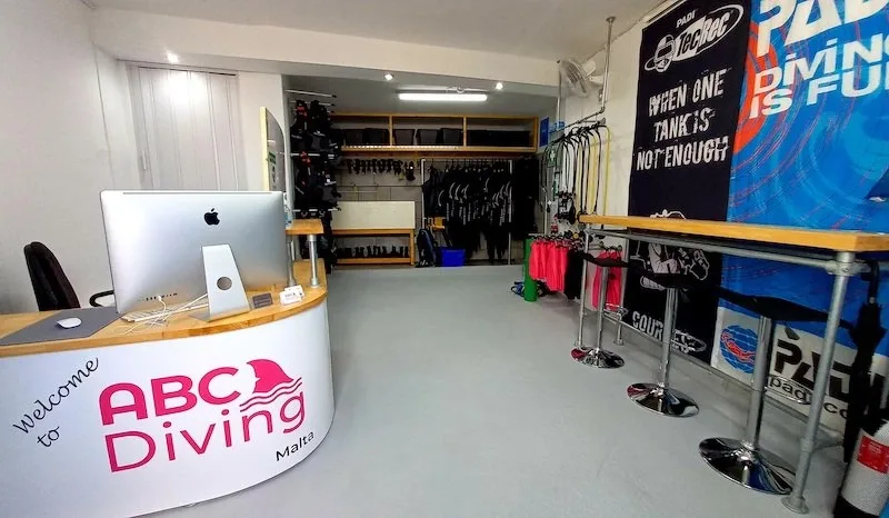 Intérieur d'un centre de plongée avec comptoir, matériel et affiches