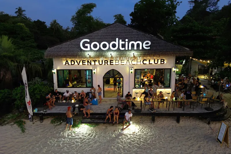 Vue nocturne d'un club de plage avec des personnes assises et debout