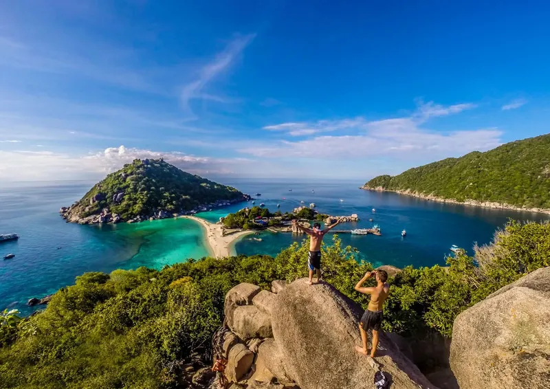 Vue panoramique d'une baie tropicale avec des personnes sur des rochers