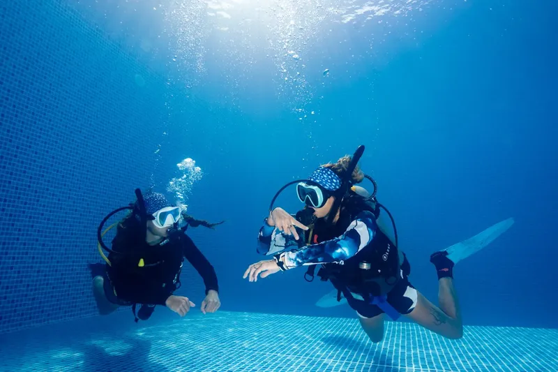 Deux plongeurs en formation dans une piscine, communication sous-marine