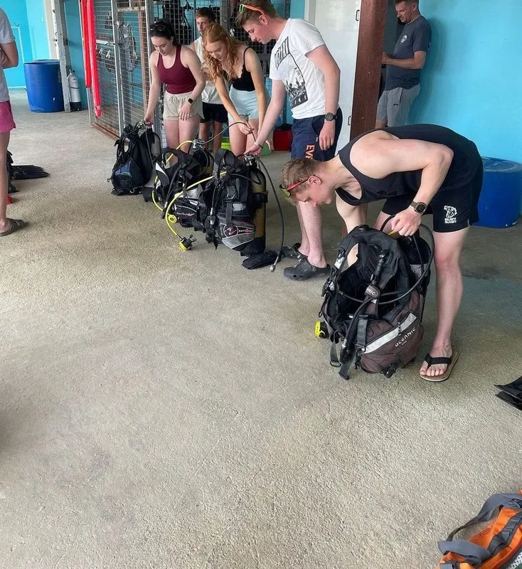 Groupe de plongeurs préparant leur équipement dans un espace intérieur