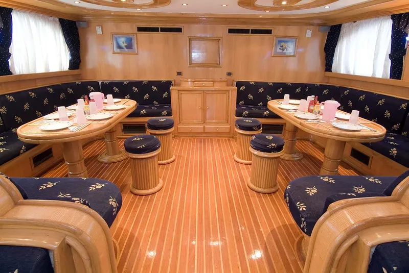 Intérieur d'un bateau de plongée avec tables, banquettes et éclairage