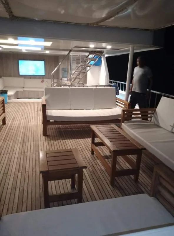 Terrasse d'un bateau de plongée avec salon et une personne debout
