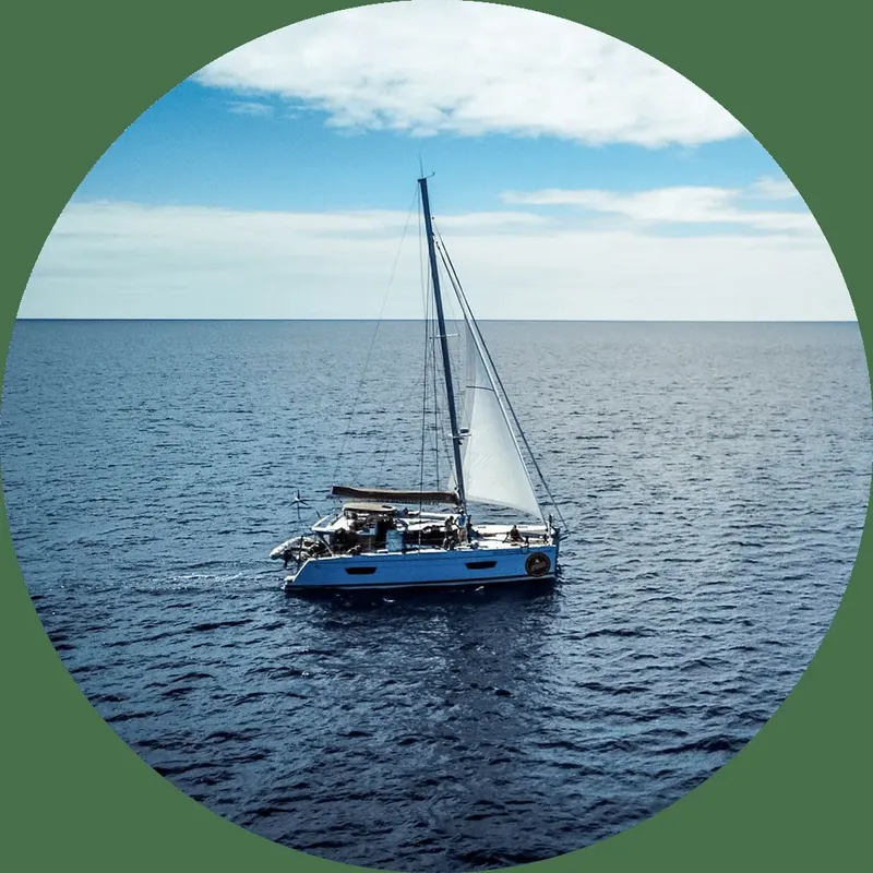 Catamaran bleu naviguant sur une mer calme sous un ciel clair