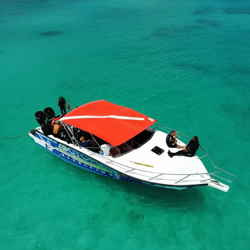 Bateau de plongée naviguant sur une eau turquoise et claire