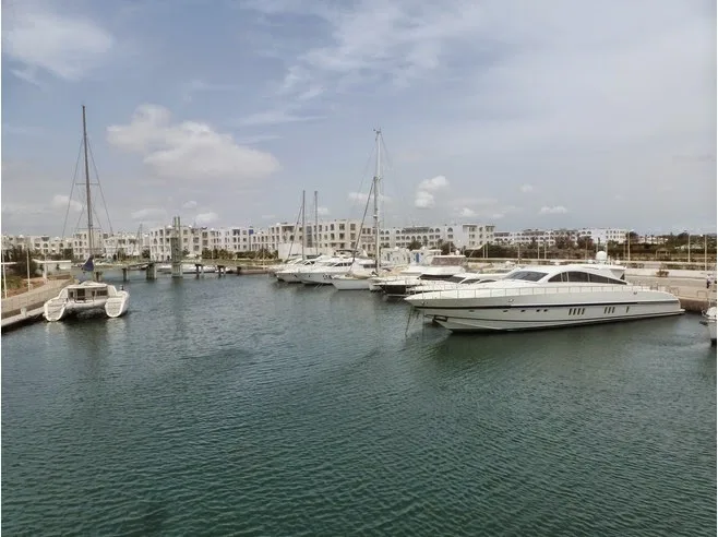 Port de plaisance avec plusieurs bateaux amarrés sous un ciel nuageux