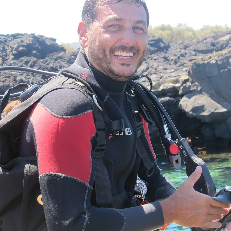 Plongeur souriant en combinaison, équipé, regardant vers l'objectif