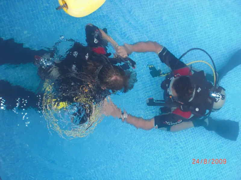 Deux plongeurs s'entraident dans une piscine, formation sous-marine