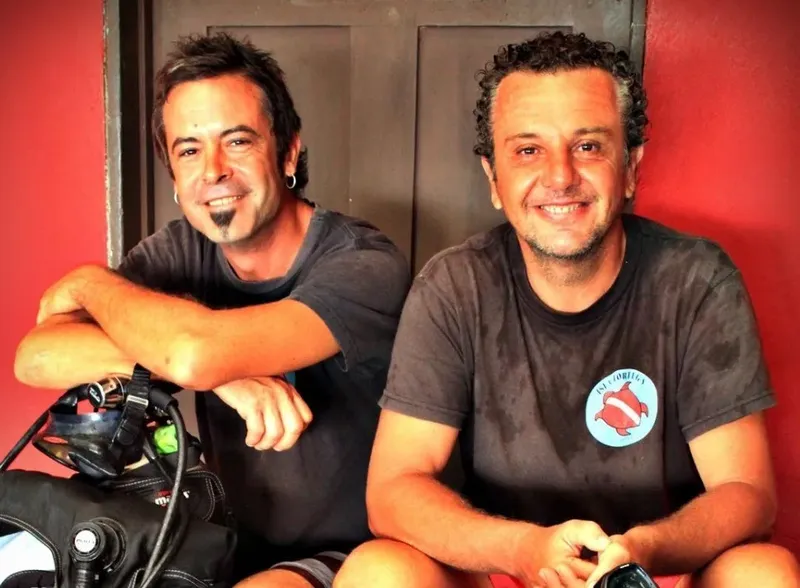 Deux hommes souriants, équipés pour la plongée, posent ensemble
