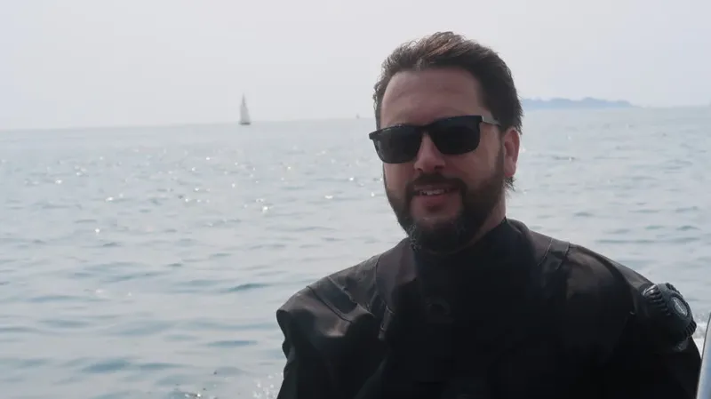 Homme souriant portant des lunettes de soleil sur un bateau en mer