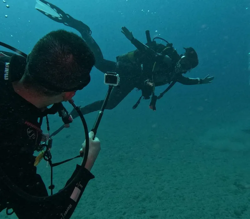 Deux plongeurs en combinaison explorent les profondeurs sous-marines bleues