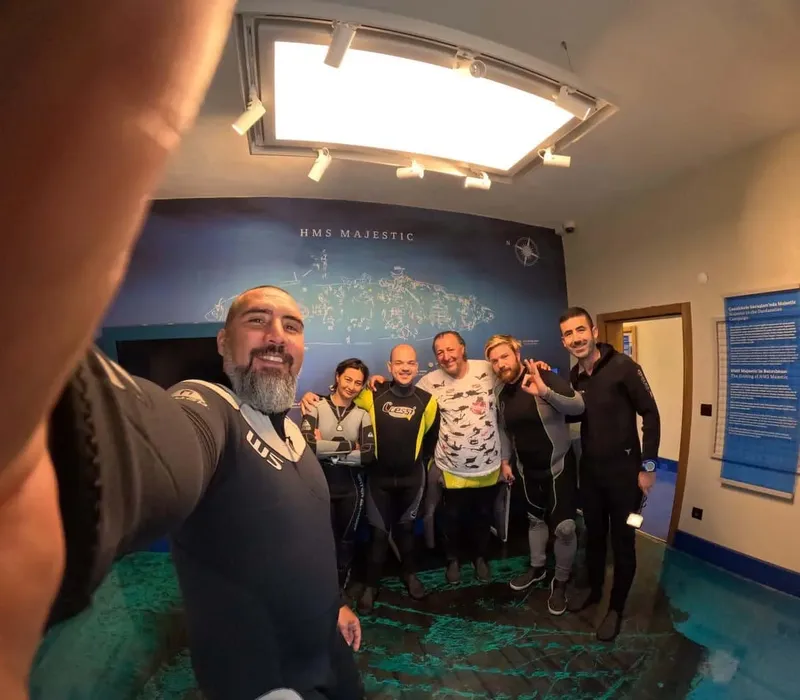 Groupe de plongeurs souriants posant dans un intérieur lumineux et moderne