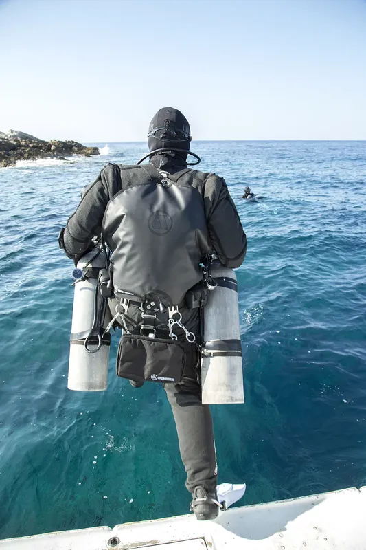 Plongeur équipé se préparant à entrer dans la mer depuis un bateau