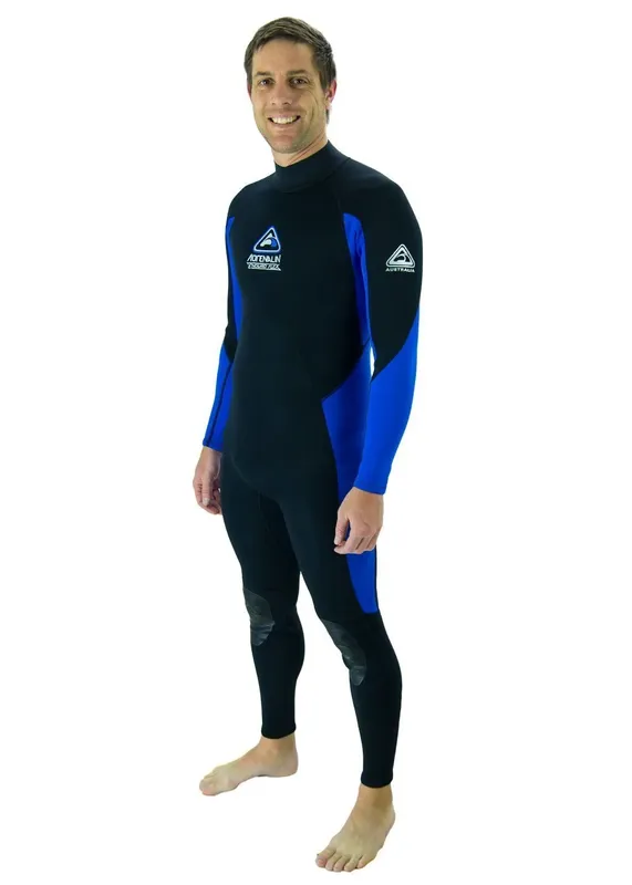 Un homme souriant porte une combinaison de plongée noire et bleue