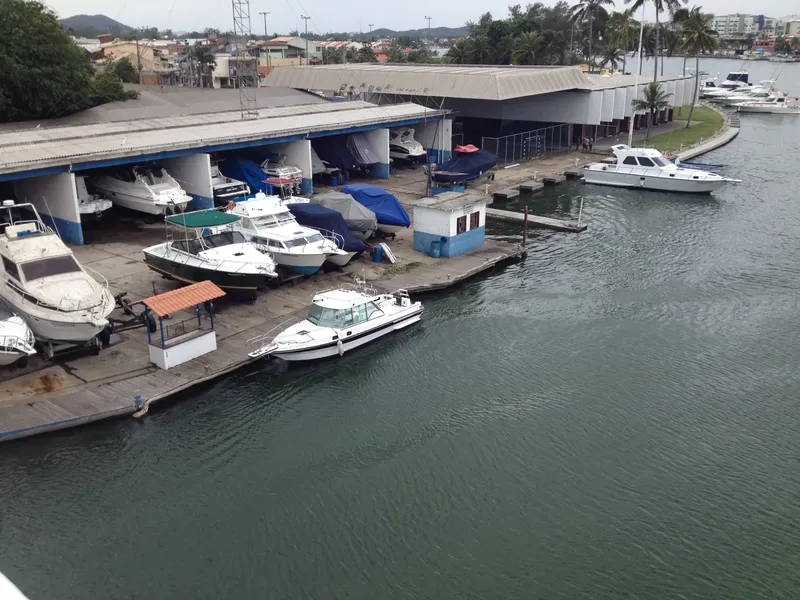 Plusieurs bateaux amarrés dans un port devant un bâtiment gris