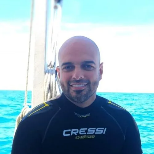 Homme souriant portant une combinaison de plongée sur un bateau