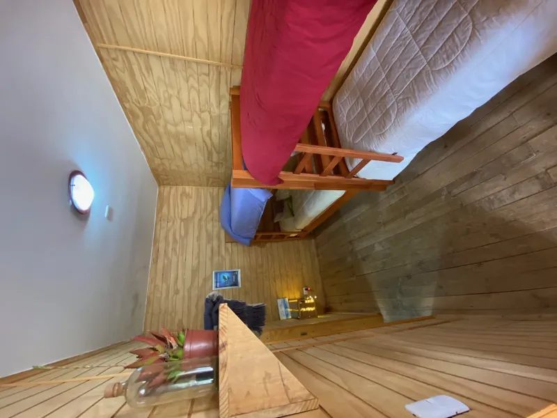 Intérieur d'une cabine en bois avec lits superposés et éclairage