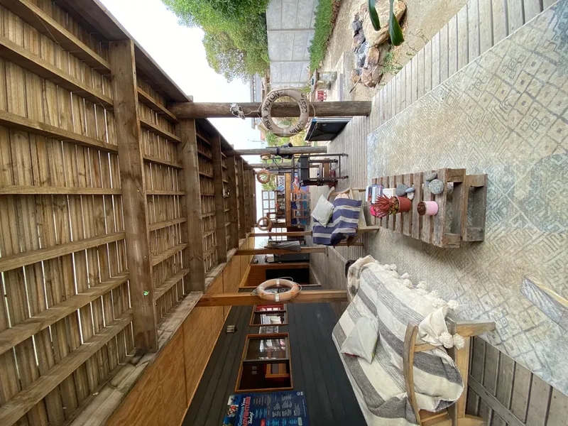 Terrasse bois avec mobilier, devanture d'un centre de plongée visible