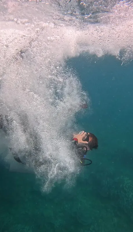 Plongeur entrant dans l'eau, bulles et vue sous-marine turquoise