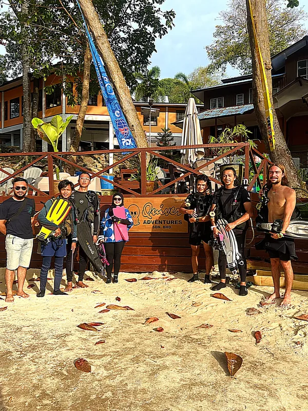 Groupe de plongeurs équipés devant le centre de plongée Quiver