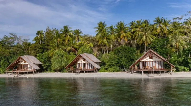 Trois bungalows en bois sur une plage tropicale ensoleillée