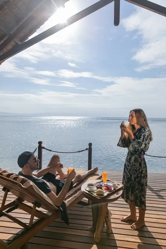 Couple se relaxant sur une terrasse en bois avec vue sur la mer