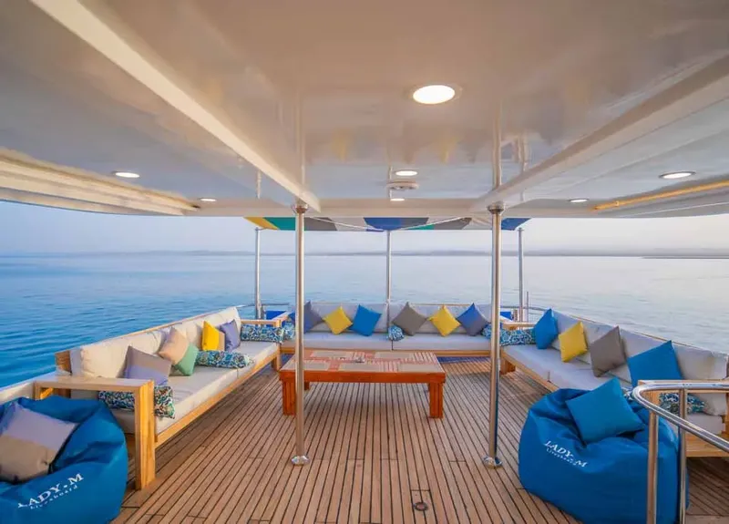 Terrasse en bois d'un bateau de plongée avec assises et vue mer