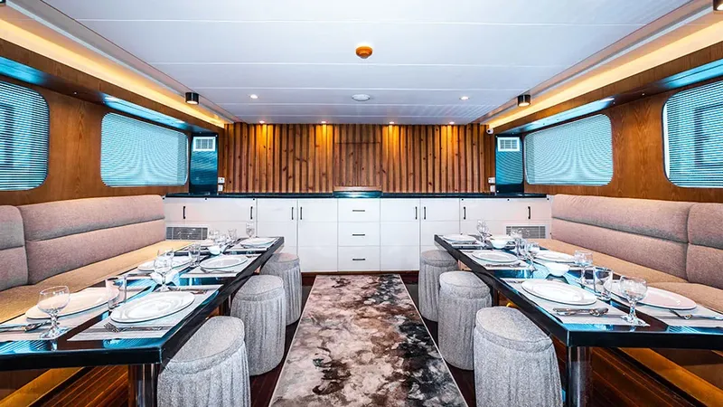 Salle à manger d'un bateau de plongée, tables dressées, intérieur clair
