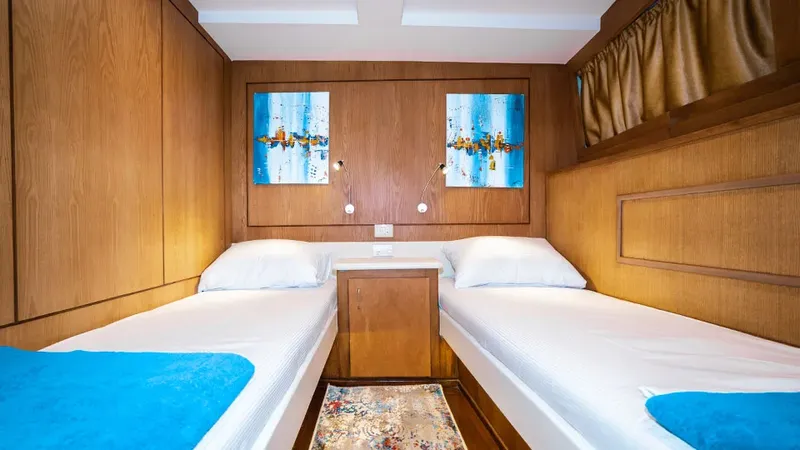 Intérieur de cabine de bateau avec deux lits et décoration murale