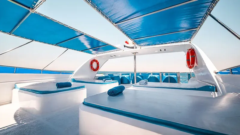 Intérieur d'un bateau de plongée avec coussins bleus et vue mer