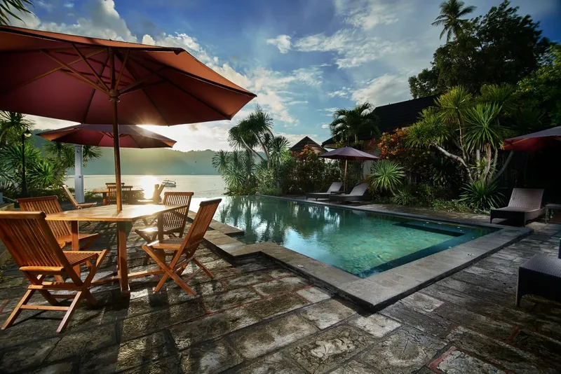 Piscine avec parasols et mobilier de jardin vue sur mer