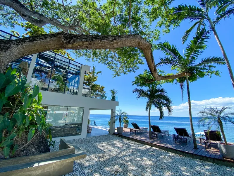 Bâtiment moderne blanc avec terrasse en bois au bord de la mer