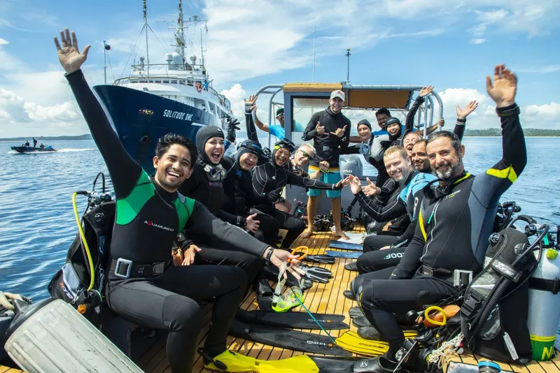 Groupe de plongeurs souriants sur un bateau en mer, joie et camaraderie