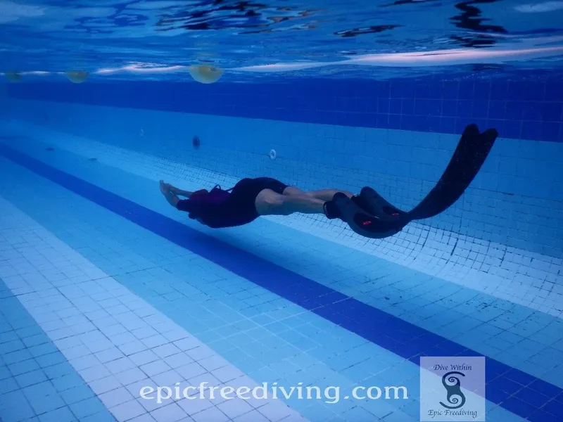 Apnée en piscine, nageur en position horizontale avec palmes et masque
