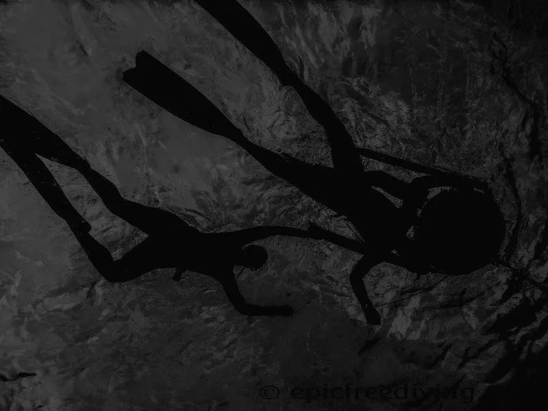 Apnéiste en silhouette sombre nageant dans une eau trouble et profonde