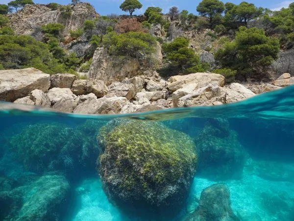 Côte rocheuse avec eau turquoise, moitié immergée, paysage méditerranéen