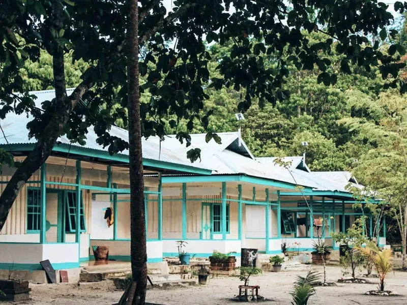 Bâtiment blanc et turquoise avec végétation luxuriante en arrière-plan