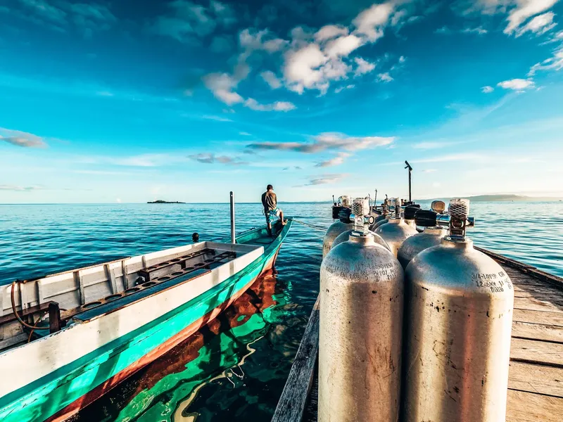Bateau de pêche coloré amarré à un ponton avec des bouteilles