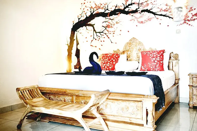Chambre d'hôtel avec lit sculpté, décoration florale et ambiance relaxante