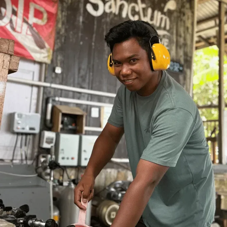Un homme souriant travaille dans un atelier de remplissage de bouteilles