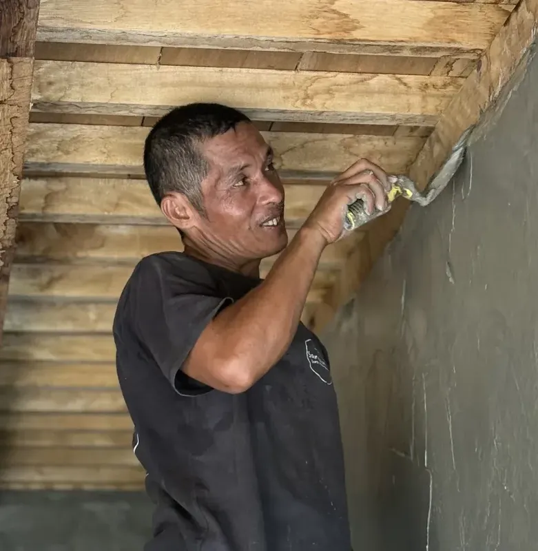 Homme travaillant sur un mur en construction dans un bâtiment en bois