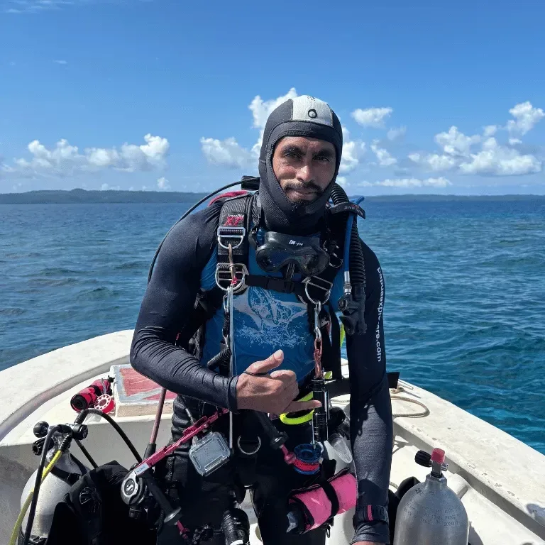Plongeur en combinaison complète assis sur un bateau en mer