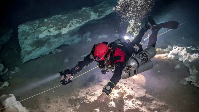 Plongeur explore une grotte sous-marine avec une ligne de sécurité