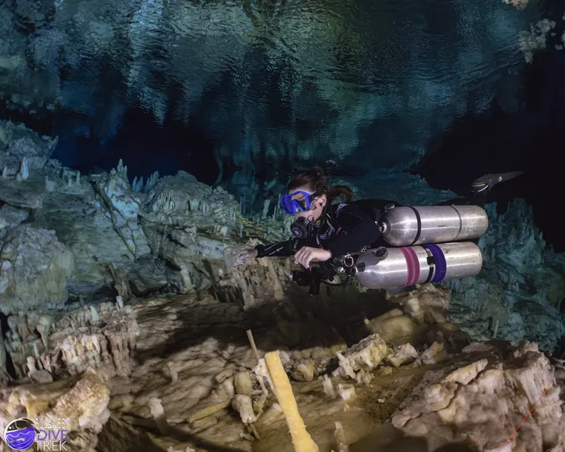 Plongeuse explore une grotte sous-marine avec stalactites et stalagmites