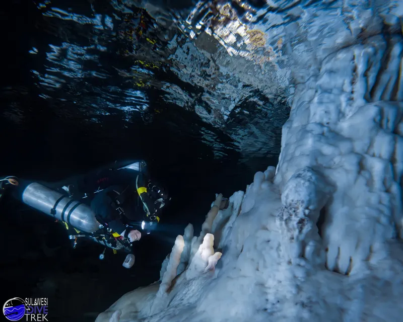 Plongeur explorant une grotte sous-marine avec des formations rocheuses